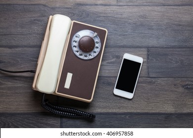 Old Retro Phone And New Cell Phone On Wooden Board, Top View