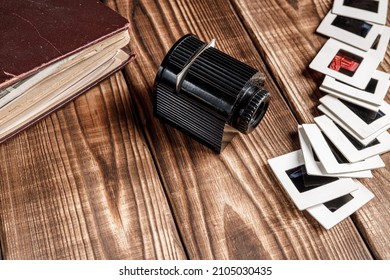 Old Retro Slide Projector, Black And White Slides And Vintage Photo Album On Brown Rustic Wood Boards