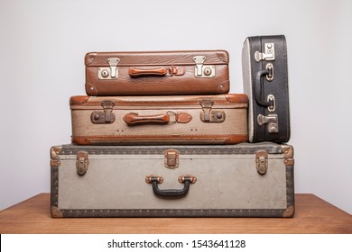 Old, retro, suitcases lie on the table with white background. Obsolete suitcase.