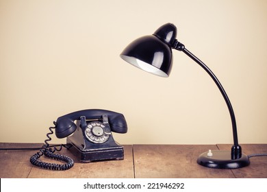 Old Retro Telephone And Desk Lamp On Wooden Table