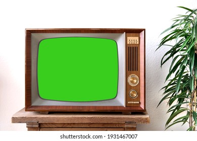 Old Retro TV With Blank Green Screen For A Designer, Video Film Stands In A Light Room On A Wooden Table, Ficus Houseplant Nearby, Concept Of A Cozy House 1960-1970, Stylish Mockup