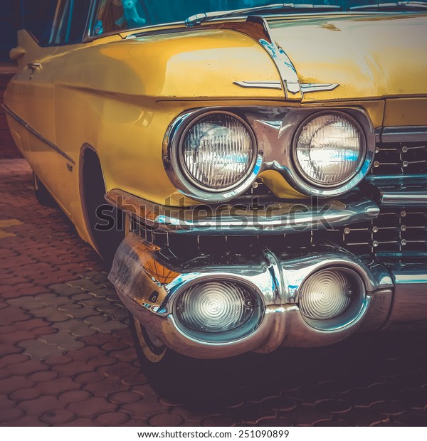 Old retro or vintage car or automobile front side\
with front lights or headlights and radiator grill. Processed by\
vintage or retro effect\
filter