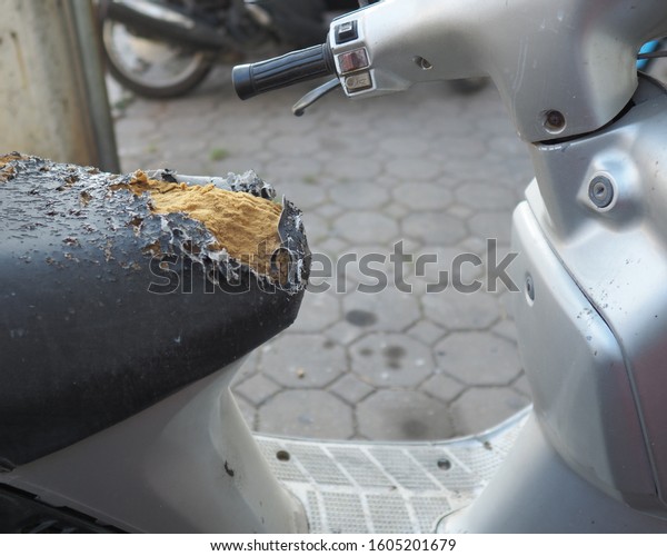 Old and
ripped motorbike seat with visible foam, detail and closeup of
damaged motorcycle seat, vintage background,Close up of a damaged
and scratched black leather motorcycle seat
