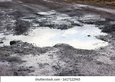 old road with a puddle - Shutterstock ID 1617122965