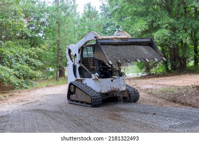 An Old Road Reconstruction Project Requires The Use Of Bobcat Tractor To Move And Unload Gravel