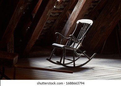 Old rocking chair on a dim attic window light