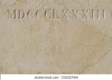 Old roman numerals engraved on a texture stone close up