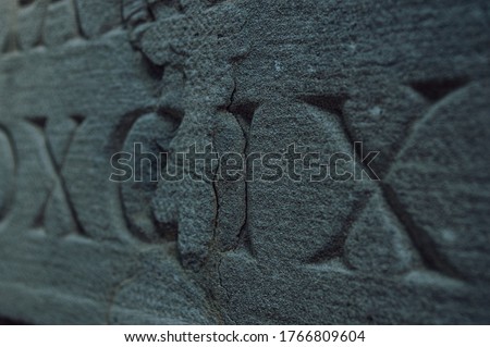Old roman numerals engraved on a texture stone close up