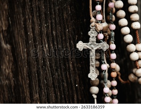 Old rosary against ancient wood doors background of church ruins. Free copy space for text.