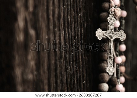 Old rosary against ancient wood doors background of church ruins . Copy space.