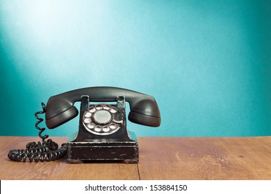 Old rotary telephone on wood table for retro background