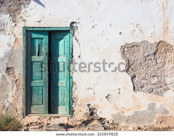 Old rotten house\
with a wooden green door