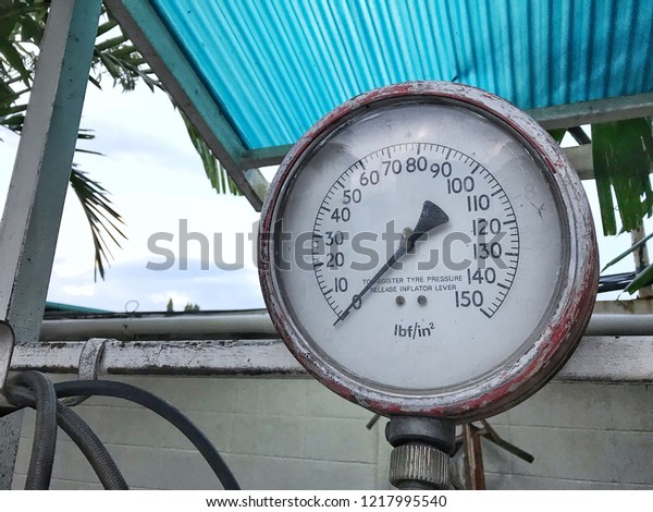 Old rubber inflator with Pressure Gauge in\
petrol station / gas\
station.