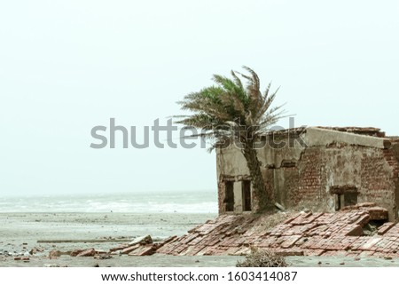 An old ruin abandoned house by sea beach. Damaged broken demolished ruined fortified brick wall building exterior. Architecture nature landscape background. Summer Travel tourism backdrop concept.