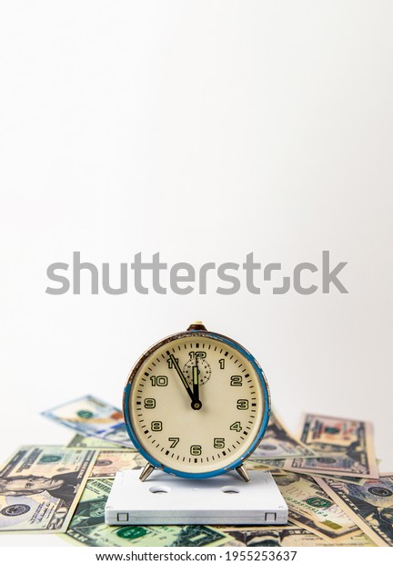 The old ruined blue analog clock is\
on a white audio music cassette, and below is cash. Everything is\
on a white background. Copy space. Music. Time.\
Money.
