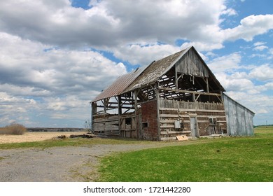 Old Rundown Barn in a Field With Cloudy Sky