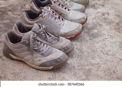 Old Running Shoes On Concrete Floor.