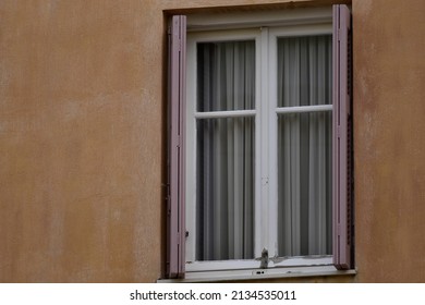 Old Rural House Window With Pink Wooden Shutters On A Venetian Stucco Wall In Nafplio, Greece.