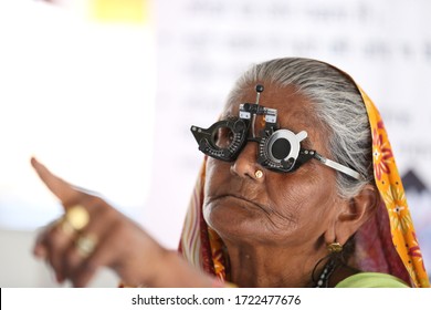 Old Rural Women From Rajasthan,India Getting Her Eyes Checked. Vision Testing. Eye Health. Eye Care For Elderly. Old Women Wearing Eye Testing Frame. Eyesight Testing Tool. 