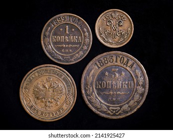 Old Russian coins 19th century, copper money on black background. Top view of vintage coins of Russia with monogram and Imperial coat of arms. Concept of rare coin, antique currency and numismatics.