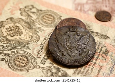Old Russian coins and vintage money banknote of 19th cent. Big copper coin of Russia 5 kopeks with Imperial coat of arms. Concept of antique rare currency, history, finance, economy and numismatics.