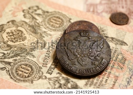 Old Russian coins and vintage money banknote of 19th cent. Big copper 5 kopeks with Imperial coat of arms. Concept of antique rare currency, history, Russia, tsar, economy, bank note and numismatics.