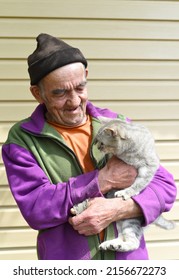 Old Russian Man Holding A Cat And Laughing