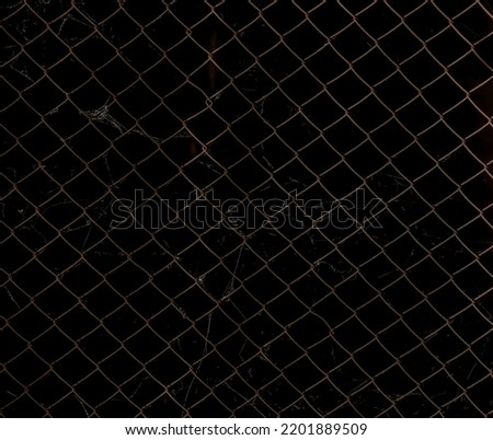 Old rust chain link fence metal wire mesh panel. isolated on Black background. spider web. Texture of rusty iron mesh, on a dark backdrop