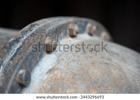 An old rusted bolt and nut hold together a metal structure.