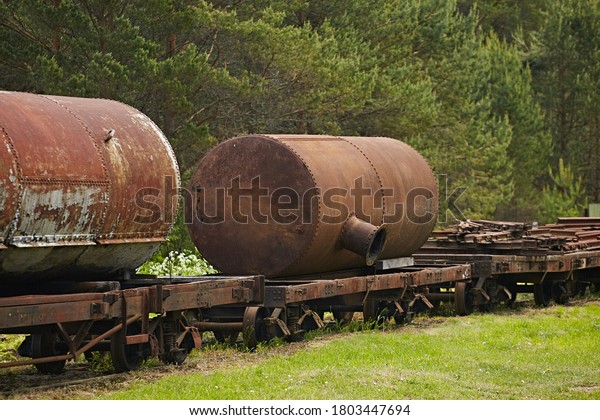 Old rusted car -\
gasoline tank for narrow-gauge railways against the backdrop of\
nature. Retro technology
