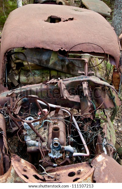 Old rusted car in junk\
yard