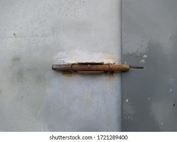 Old Rusted Dead Bolt On Grey Steel Door