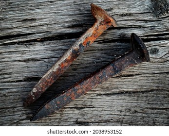 Old Rusted Iron Steel Railroad Spikes On Wood Surface