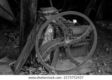 An old rusted iron wheel placed against other vintage objects at an historical heritage listed homestead