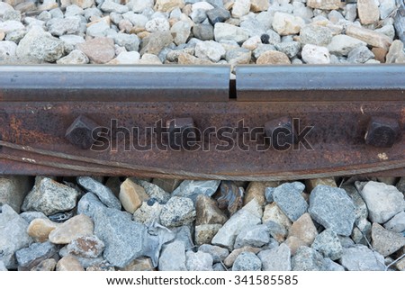 old rusted screw on railroad. rusty metal rail track fixed on stone