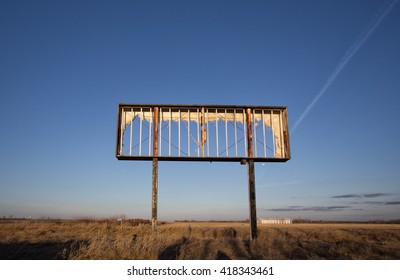 An Old Rusted Steel Billboard Frame In A Countryside Sunset