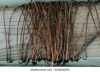 Old Rusted Steel Wire Coiled Around A Wooden Plank. Bent In Thinned Spots. Texture. Background.