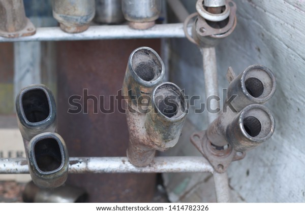 Old and rusted\
used exhaust in auto work\
shop.