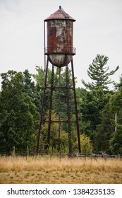 Old Rusted Water Tower In Field