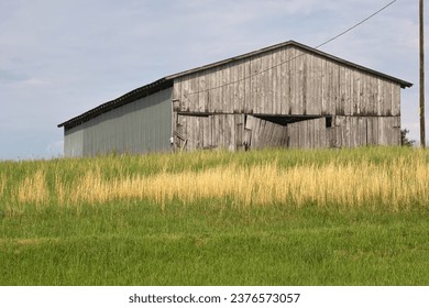 An old rustic barn sitting in a field.