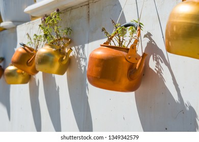Old rustic copper kettles with plants hanging on white wall. Souq Waqif market, Doha, Qatar - Shutterstock ID 1349342579