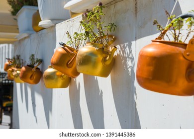Old rustic copper kettles with plants hanging on white wall. Souq Waqif market, Doha, Qatar - Shutterstock ID 1391445386
