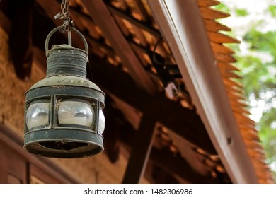 Old rustic lantern hanging on wooden roof, Rural style decoration.