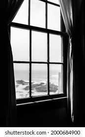 Old rustic light house window interior looking outside to the ocean. Lonely isolated feeling and dramatic lighting monochrome