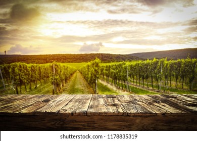 Old Rustic Table In A Beautiful Vineyard At Sunset