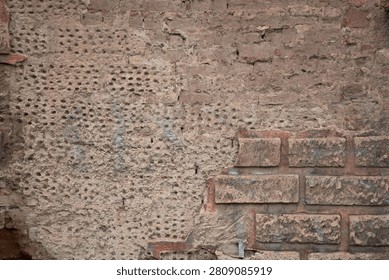 Old rustic wall background texture with chipped plaster, adobe and brick blocks