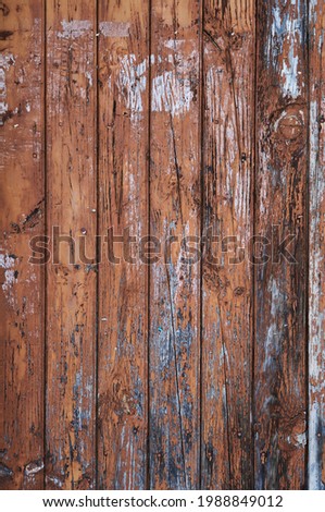 Old rustic wooden planks door with brown peeling paint, grunge background or texture