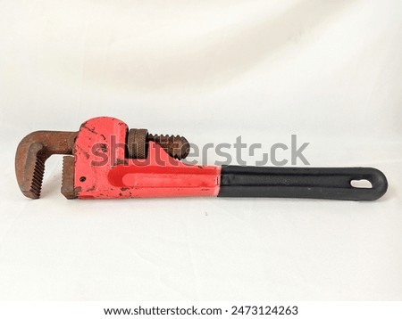 Old rusty Adjustable Pipe Wrench With Red Metal Handle For Tightening Nuts Bolts And Pipes Isolated On White