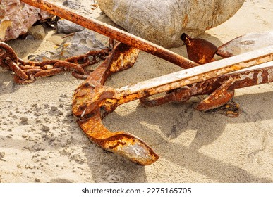 Old, rusty anchor and chains on a sandy beach, capturing the rugged beauty of the coast. - Powered by Shutterstock