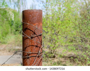 Old and rusty barbed wire on a metal pole. Ghost Town Pripyat